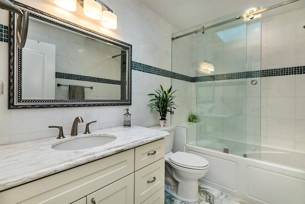 Bathroom remodel with frameless glass shower and marble vanity