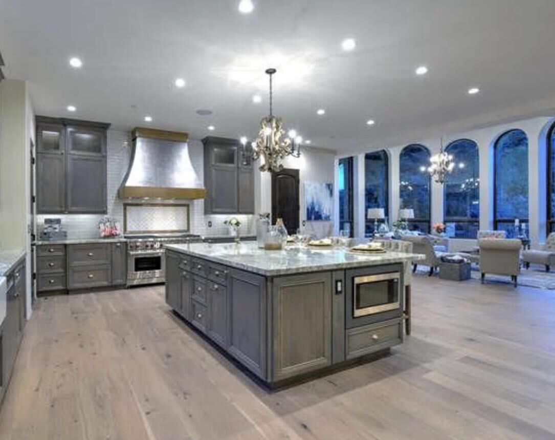 Open-concept kitchen with island, arched windows and hardwood floors