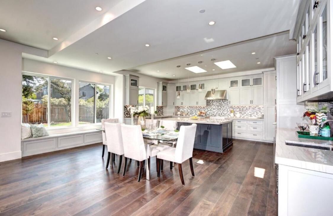 Modern white and gray kitchen open to a dining area